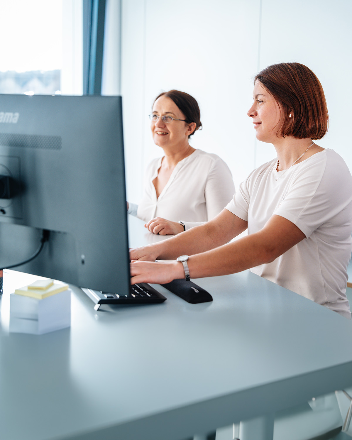 zwei Damen am Arbeitsplatz fleißig am arbeiten