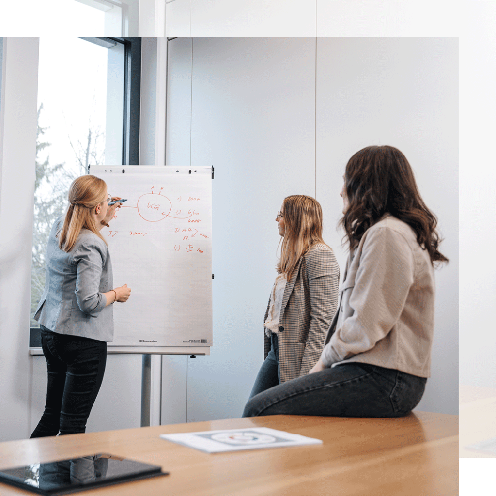 drei junge Damen arbeiten am Whiteboard gemeinsame etwas aus